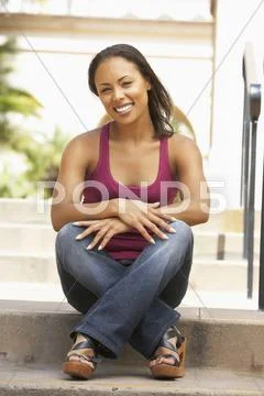 Young woman sitting on steps of building Stock Photos