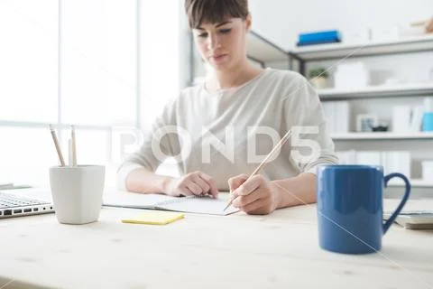 Young woman sketching on a notebook Stock Photos