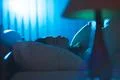 The young woman sleeping on the bed. Evening night time Photo