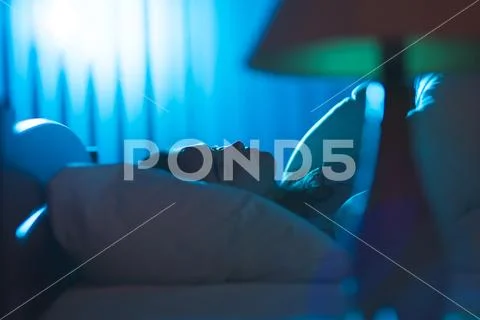 The young woman sleeping on the bed. Evening night time Stock Photos