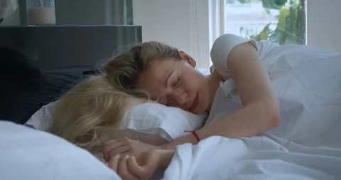 Young woman sleeping while lying in comfortable bed in bedroom. Young beautiful Stock Footage 243422748