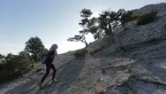 Young Woman With Small Backpack Climbing And Reaching The Top Of A Mountain Stock Footage