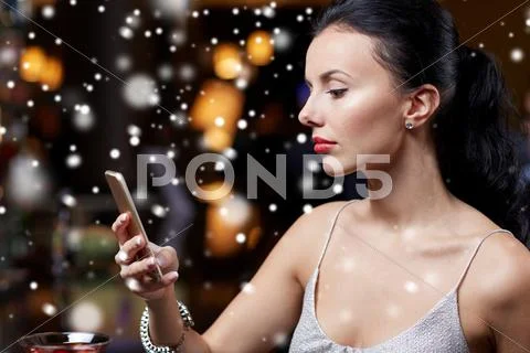 Young woman with smartphone at night club or bar Stock Photos