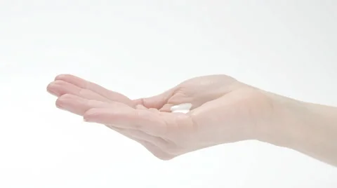 Young woman smearing body lotion on hands on white background Stock Footage