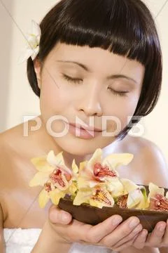 Young woman smelling blossom, portrait, close-up Stock Photos