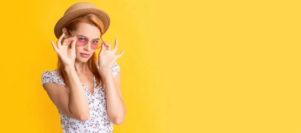 Young woman smile in straw hat and sunglasses on yellow. Woman isolated face Stock Photos