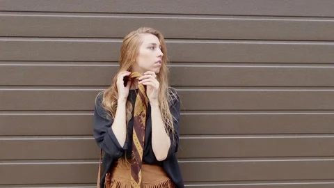 Young woman smiles and looks at the camera, posing and showing dress. Stylish Stock Footage