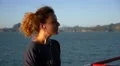 Young Woman Smiling and Listening Music in Headphones against Beautiful Sea on HD Footage
