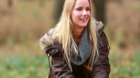 Young woman smiling and throwing leaves in the air Stock Footage 59554401