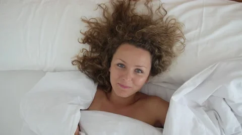 Young Woman Smiling in Bed at Home, Top View Stock Footage 59149917