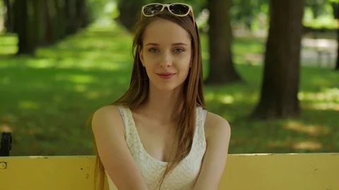 Young woman smiling to the camera in a park Stock Footage
