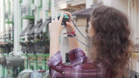Young woman smiling to the camera while taking photos outdoors Stock Footage 115328471