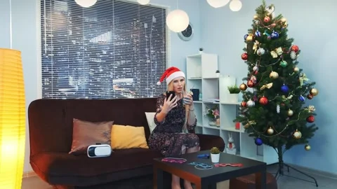 Young woman smiling with drink and smartphone on sofa at home Video stock 340962053