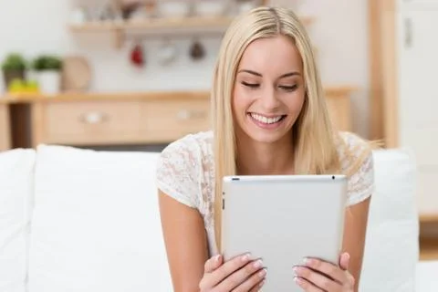Young woman smiling as she reads an e-book Stock Photos