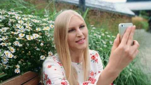 Young woman smiling using smartphone on living roof bench outdoors Video stock 340565716