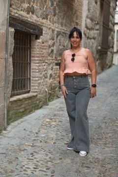 Young woman smiling while exploring old European alley Stock Photos