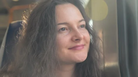 Young woman smiling while looking out train window joyfully Vídeo Stock 288019977