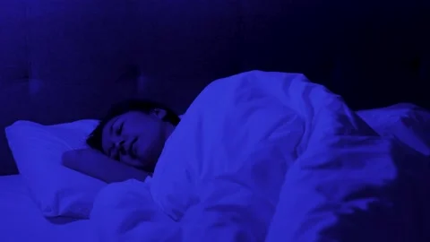 Young woman smiling while sleeping on bed in bedroom. Woman sees good dreams Stock Footage 295284703