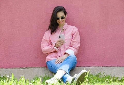 Young Woman Smiling While Using Smartphone, portrait of beautiful happy gir.. Stock Photos