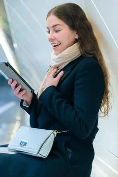 Young Woman Smiling While Using digital tablet in Modern Subway Station.Vertical Foto stock