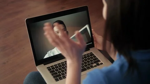 Young woman smiling while videoconferencing at home during coronavirus self Stock Footage 130275994