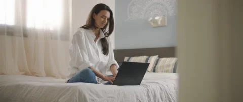A young woman smiling while working on her computer from home. Stock Footage 132366467
