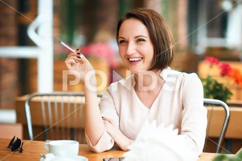 Young woman smokes tobacco in a cafe Stock Photos