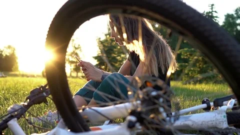 Young woman sms texting using app on smart phone with in city park at sunset. .  Stock Footage 77467389