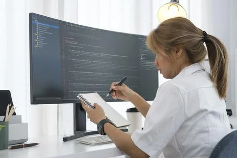 Young woman software developer working with program code on wide displays a.. Stock Photos