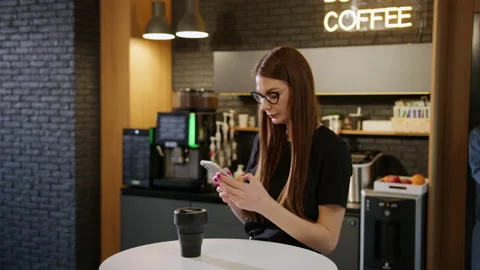 A young woman solves work issues on the phone in an office cafe point Stock Footage 195209541