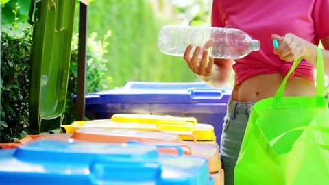 Young woman sorting garbage in the yard of the house Stock Footage 207982372
