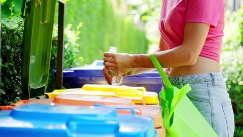 Young woman sorting garbage in the yard of the house Stock Footage 210987984