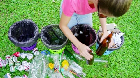 Young woman sorting garbage in the yard of the house Stock Footage 210988313