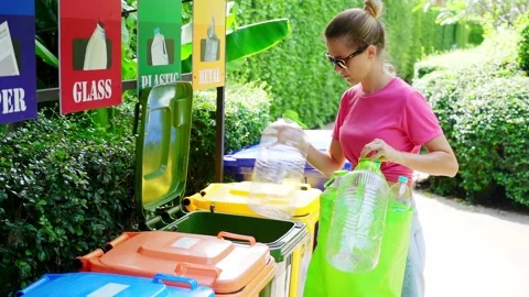 Young woman sorting garbage in the yard of the house Stock Footage 212839454