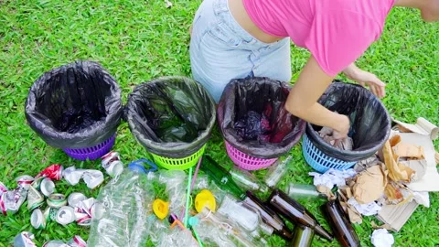 Young woman sorting garbage in the yard of the house Stock Footage 216411121