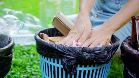 Young woman sorting papper trash in the yard of the house Stock Footage 207981879