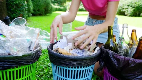 Young woman sorting papper trash in the yard of the house Video stock 209119801