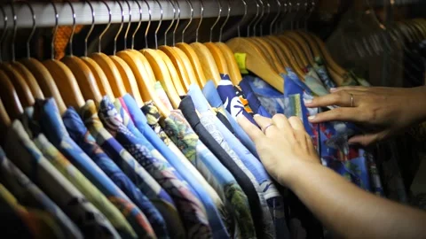 Young Woman Sorting Through Clothes on a Hanger and Choosing Summer Vacation Stock Footage 233416654