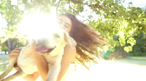 Young woman spinning with her labrador dog in slow motion Stock Footage