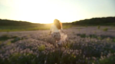Young Woman Spins Slow Motion in a field of Flowers at Sunset Stock Footage