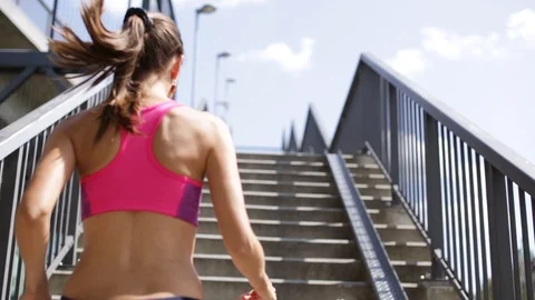 Young woman with sport oufit rising a stair in a sunny day Stock Footage
