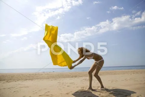 Young woman spreading bath towel Stock Photos