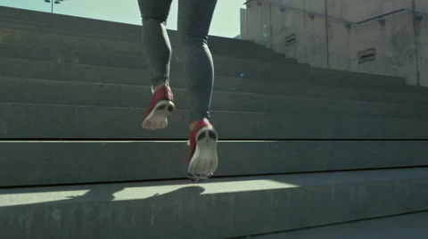 Young woman sprinting up the stairs Stock Footage