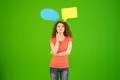 The young woman stand with a dialog signs on the green background Photo