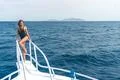 The young woman stand in the yacht on the sea background Photo