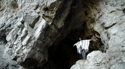 Young woman standing with backpack on cliff's edge and looking into Stock Footage 63401938