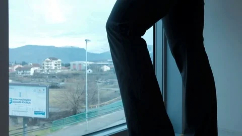 Young woman standing by panoramic window in room indoors Stock-Footage 75817536