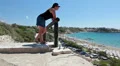 Young woman standing on viewpoint in Coral Bay and looking at seacost, Cyprus HD Footage
