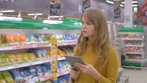 Young woman in the store checking list of products on touch pad Stock Footage 75276259