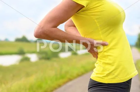Young woman stretching with her hands to her back Stock Photos